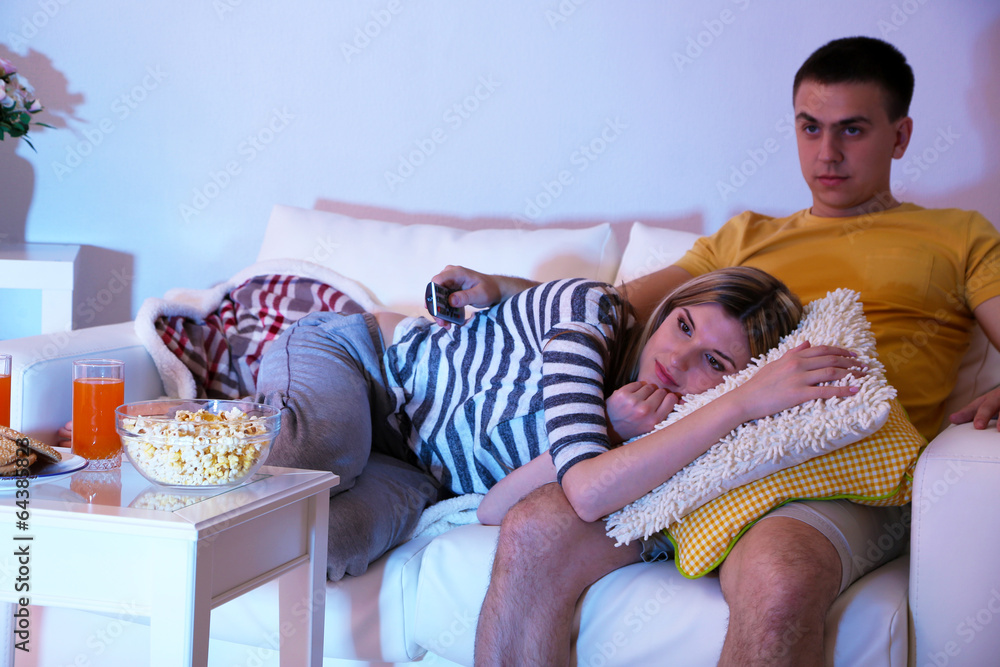 Young couple watching television at home of blacking-out