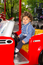 Todder In Red Car In Amusement Park