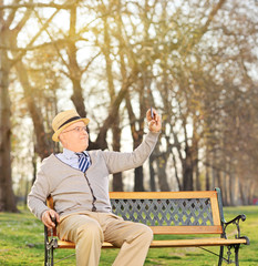 Poster - Senior adult taking a selfie in park