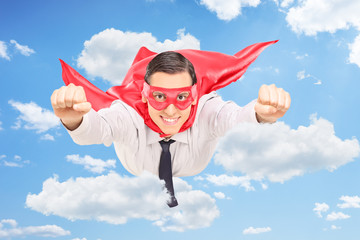 Wall Mural - Superhero flying through the clouds in the sky