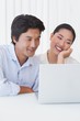 © WavebreakmediaMicro - Happy couple using laptop together