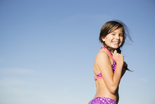 A Young Child In A Bikini With Plaited Hair.