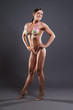 © ysbrandcosijn - Muscled fitness woman wearing bikini. Brown hair. Studio shot ag