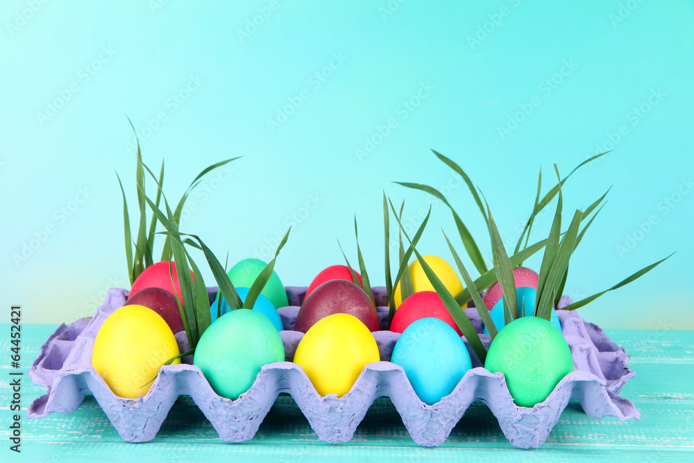 Colorful Easter eggs with grass in tray