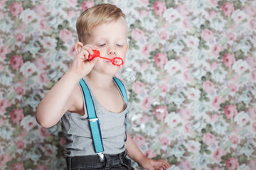 Wall Mural - beautiful joyful blond boy blowing soap bubbles