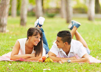 Two people sitting in the park on a picnic and having fun