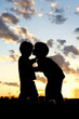 Big Brother Kissing Baby Silhouette at Sunset