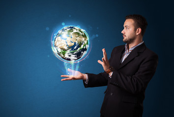 Wall Mural - Businessman holding glowing earth globe