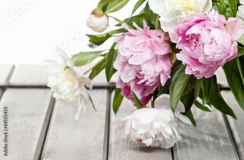 Obraz w ramie Stunning peonies in white wicker basket on rustic wooden table