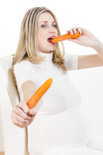 Portrait Of Pregnant Woman Eating Carrot