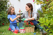 © goodluz - Little girl helping her mother to do gardening