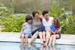 © goodluz - Parents with children relaxing by the pool