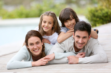 Wall Mural - Happy family of four laying by the pool