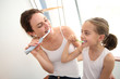 © goodluz - Mother teaching little girl how to brush her teeth