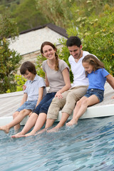 Wall Mural - Parents with children relaxing by the pool