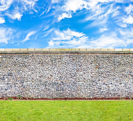 Wall Mural - stone wall with the lawn and skies horizontal seamless image