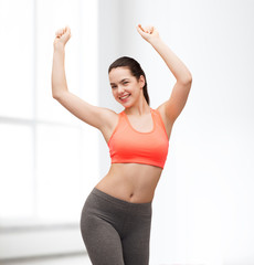 Wall Mural - smiling teenage girl in sportswear dancing