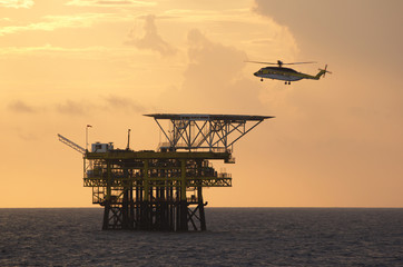 A helicopter transports roughnecks to a rig