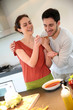 © goodluz - Couple having fun in kitchen tasting cooked sauce