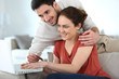 © goodluz - Couple at home shopping online with laptop