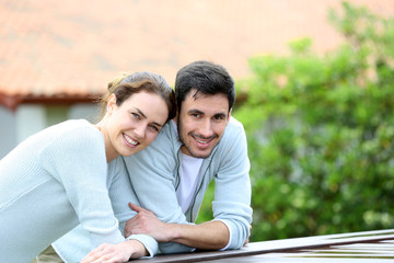 Wall Mural - Couple embracing each other in front of house