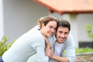 Wall Mural - Couple embracing each other in front of house