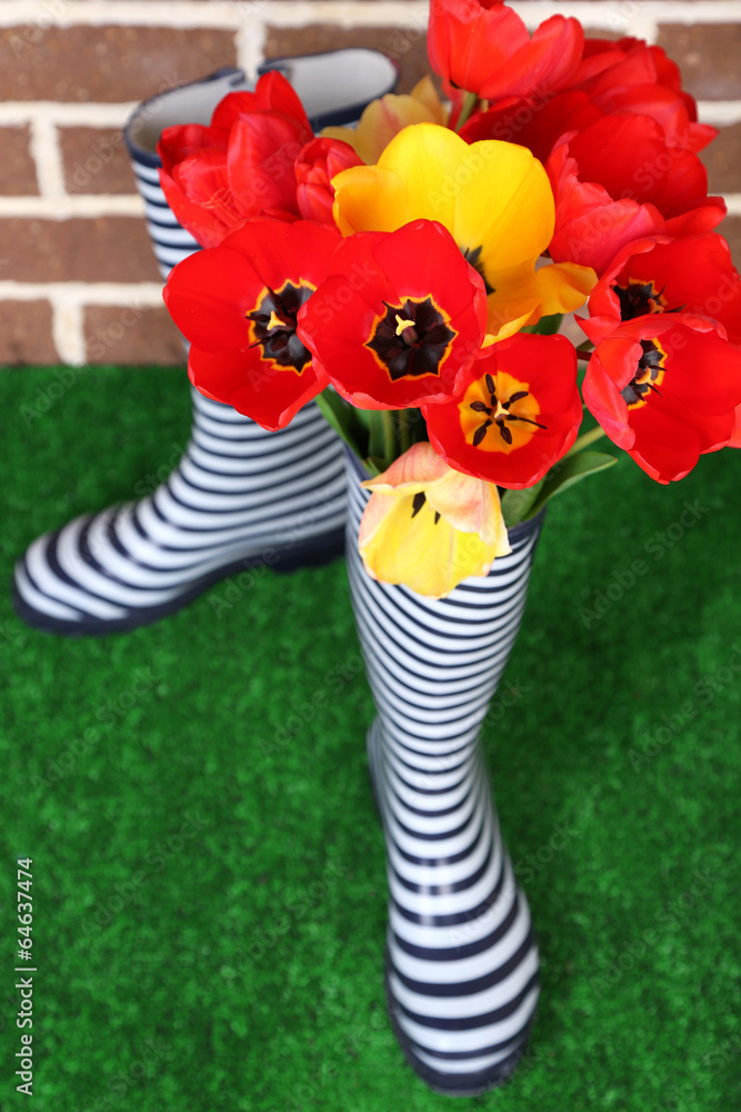Composition of colorful tulips in rain boots