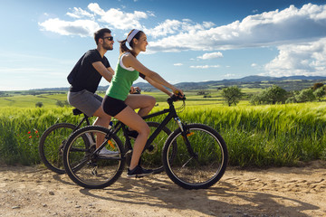 Happy young  couple on a bike ride in the countryside