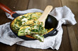 Scrambled eggs with onions, zucchini and herbs. Selective focus