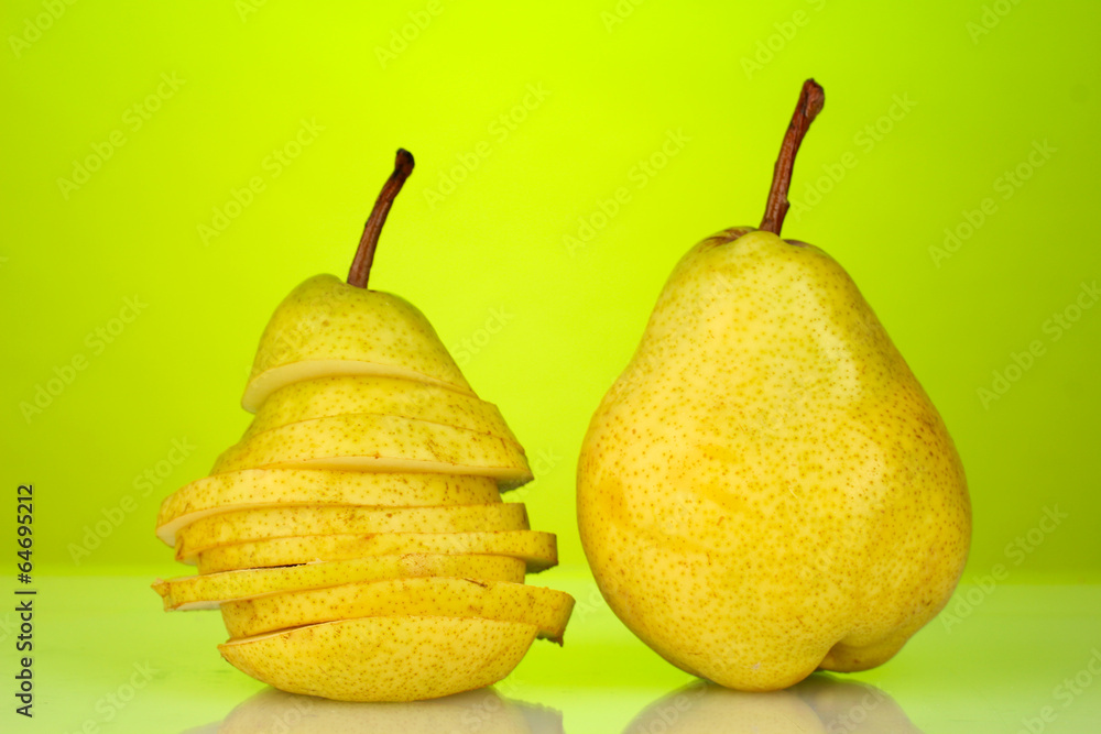 Ripe pears on bright green background