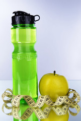 Canvas Print - Sports bottle, apple and measuring tape on grey background