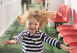 Little blonde girl running with windswept hair