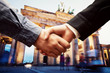 © Photocreo Bednarek - Business in Berlin. Handshake on Brandenburg Gate