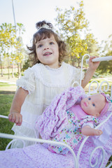 Wall Mural - Adorable Young Baby Girl Playing with Baby Doll and Carriage