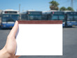 white blank notebook in woman hand and bus station background