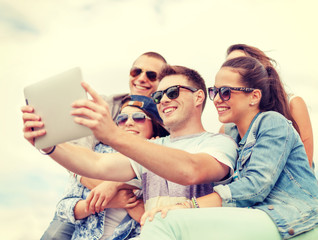 Wall Mural - group of smiling teenagers looking at tablet pc