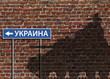 Shadow of tank on brick wall with sign