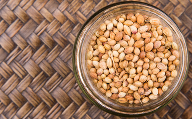 Wall Mural - Coriander seed over a wicker background 