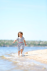 Wall Mural - Beautiful little girl on the beach