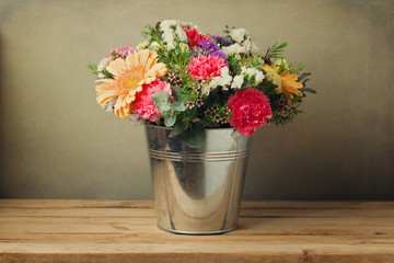 Wall Mural - Flower bouquet in bucket on wooden table