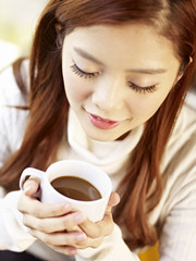 Wall Mural - young woman holding cup of coffee high angle view