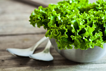 lettuce salad in metal bowl and spoons