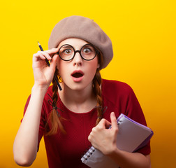 Sticker - Redhead girl with notebook and pencil on yellow background.