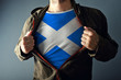 © Bits and Splits - Man stretching jacket to reveal shirt with Scotland flag