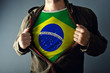 © Bits and Splits - Man stretching jacket to reveal shirt with Brazil flag