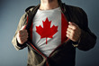 © Bits and Splits - Man stretching jacket to reveal shirt with Canada flag