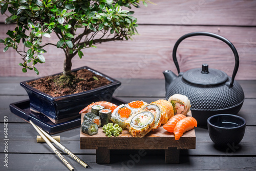 Naklejka samoprzylepna Sushi serwowane na drewnianej desce z herbatą