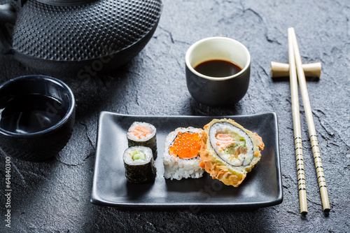 Naklejka samoprzylepna Zbliżenie sushi na czarnym ceramicznym naczyniu
