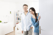 © jackfrog - Cheerful couple inviting people to enter in home