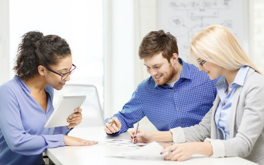 Canvas Print - smiling team with table pc and papers working